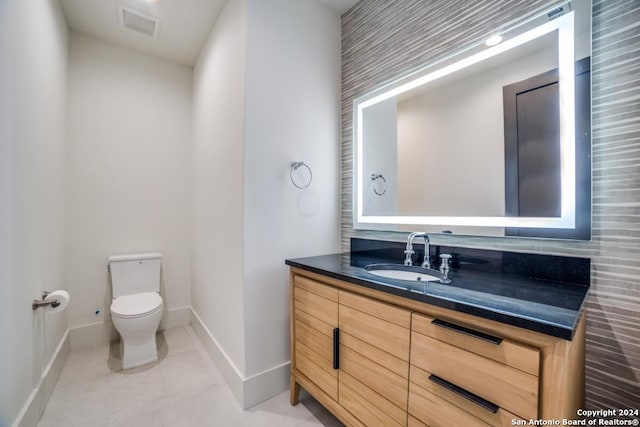 bathroom featuring vanity, tile patterned flooring, and toilet