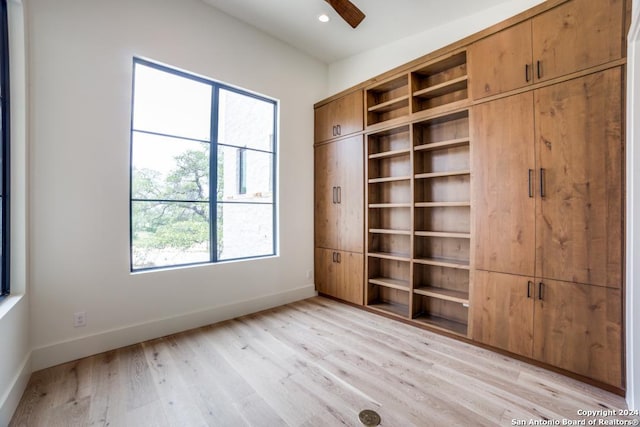 unfurnished bedroom featuring multiple windows, ceiling fan, and light wood-type flooring