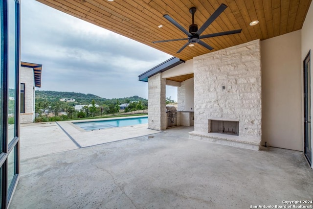 view of pool with area for grilling, a mountain view, a patio, and ceiling fan