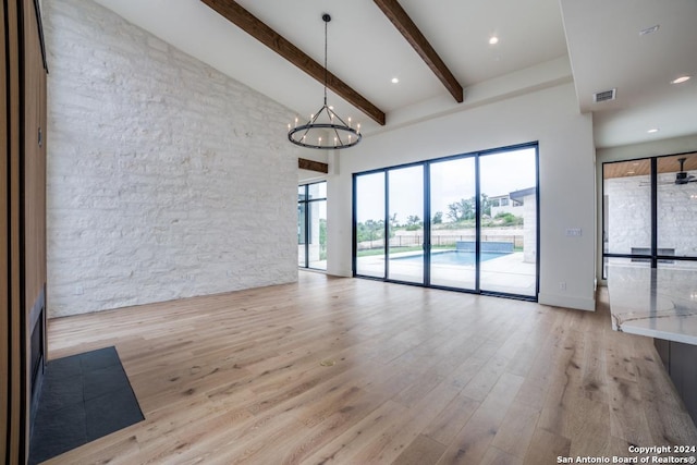 unfurnished living room with an inviting chandelier, light hardwood / wood-style flooring, high vaulted ceiling, and beamed ceiling