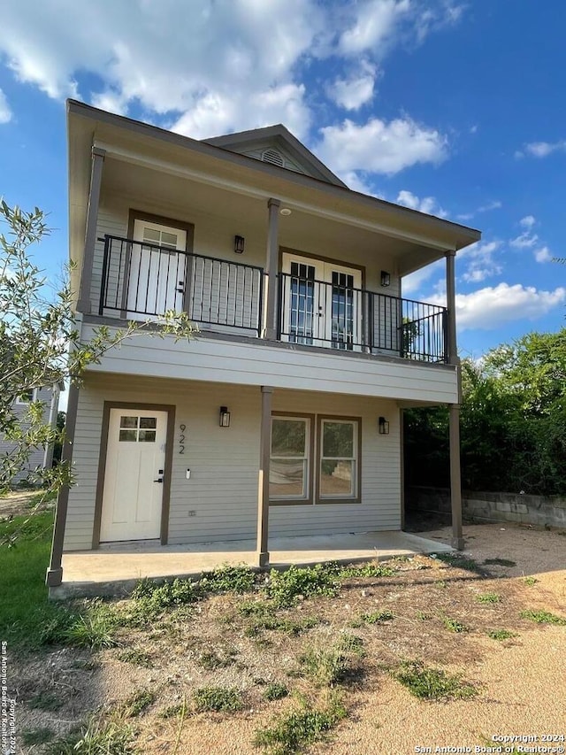 view of front of home featuring a balcony and a patio