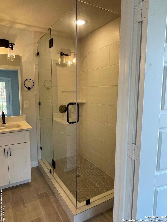 bathroom featuring tile floors, an enclosed shower, and vanity