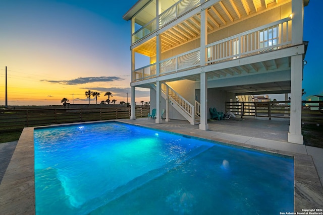 pool at dusk with a patio