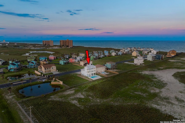 aerial view at dusk featuring a water view