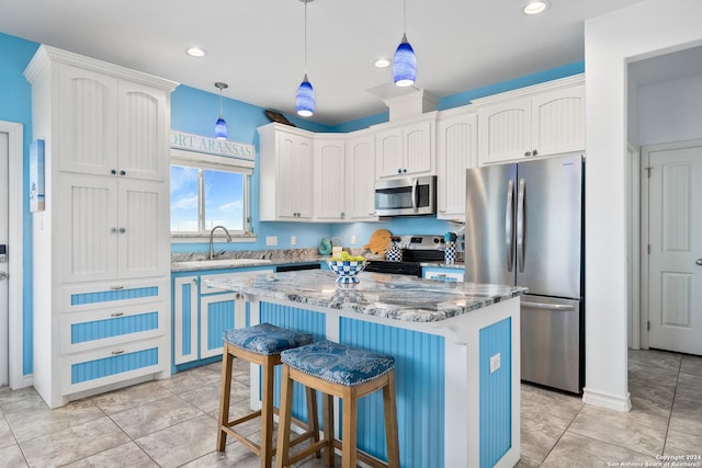 kitchen featuring pendant lighting, stainless steel appliances, a kitchen breakfast bar, and a kitchen island