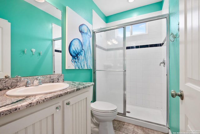 bathroom with tile patterned floors, vanity, toilet, and an enclosed shower