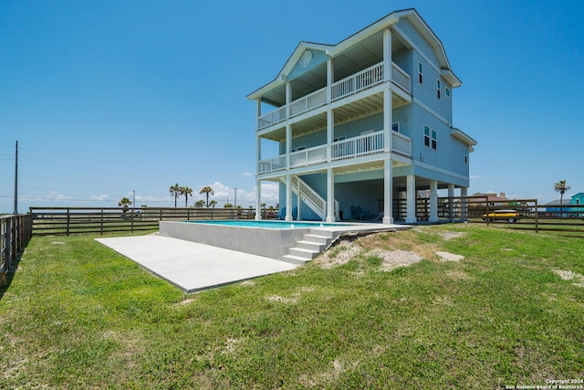 back of property featuring a fenced in pool and a yard