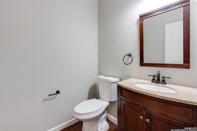 bathroom with vanity, hardwood / wood-style flooring, and toilet