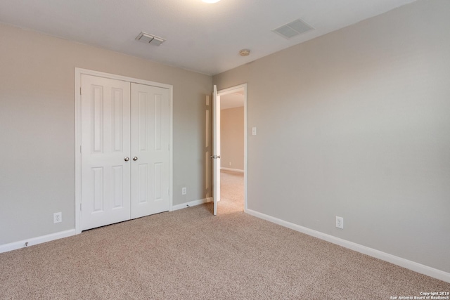 unfurnished bedroom with a closet and carpet floors