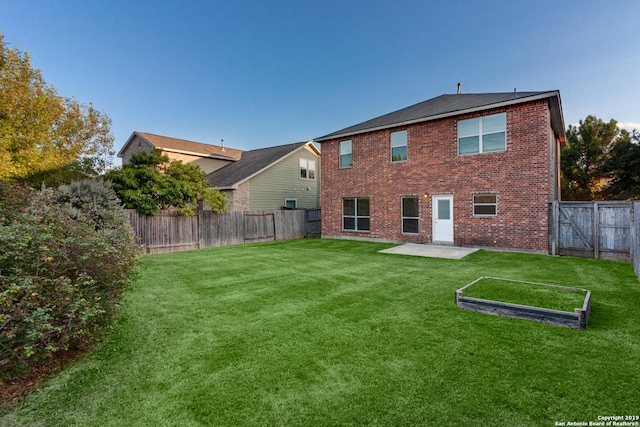 back of house with a patio and a lawn