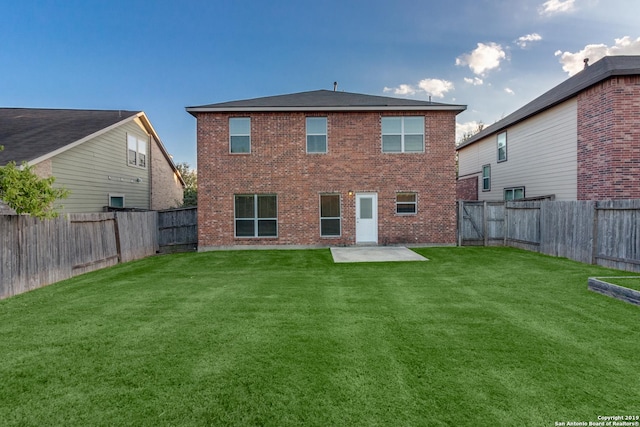 back of house with a lawn and a patio