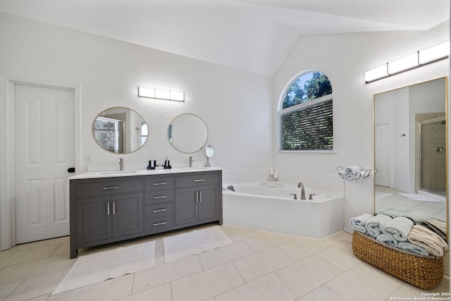 bathroom featuring vaulted ceiling, tile patterned floors, separate shower and tub, and vanity