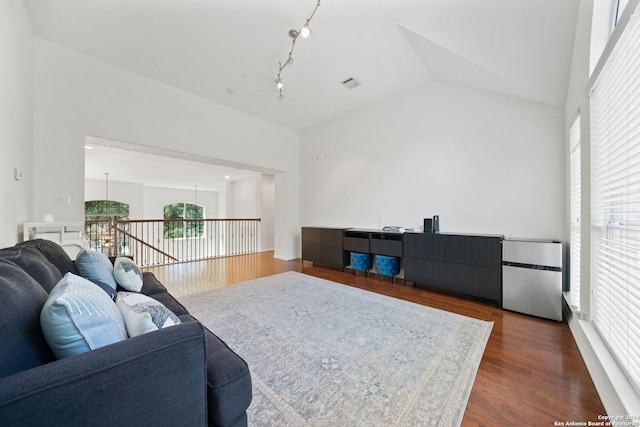 living room featuring vaulted ceiling, dark hardwood / wood-style flooring, and a notable chandelier