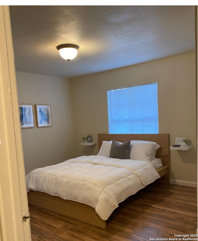 bedroom with dark hardwood / wood-style flooring