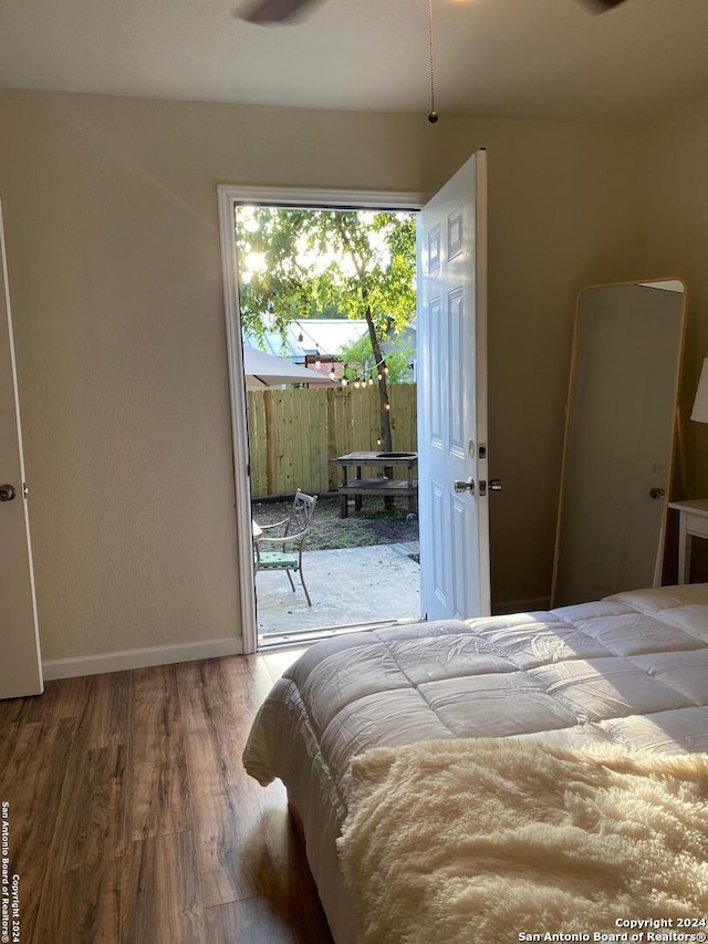 bedroom featuring access to exterior and hardwood / wood-style floors