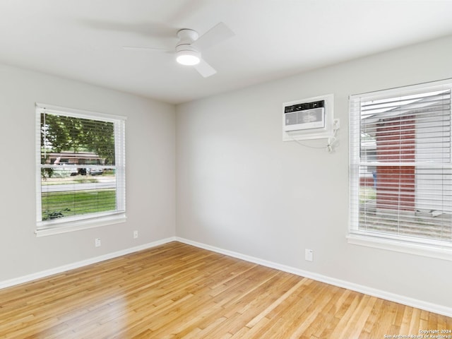 empty room with an AC wall unit, ceiling fan, and light hardwood / wood-style flooring