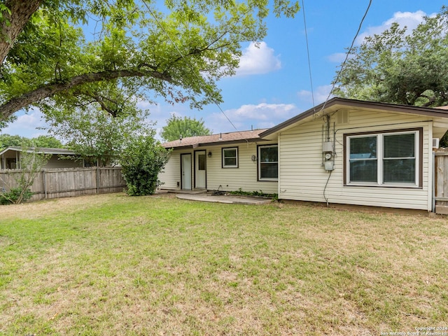 rear view of property with a yard and a patio area