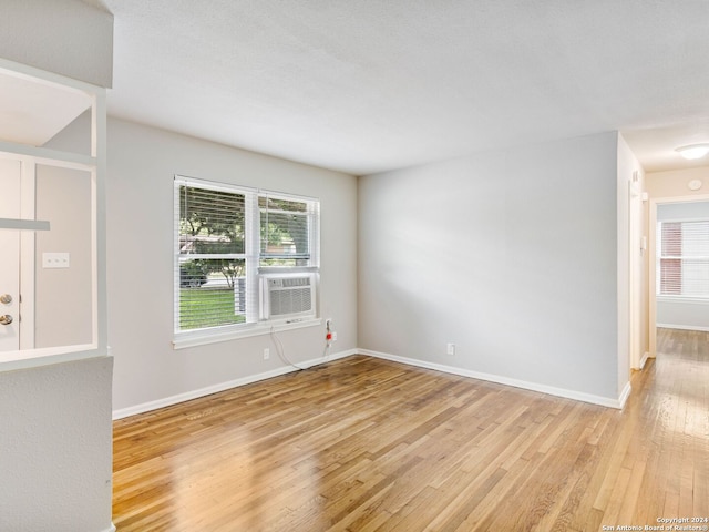 spare room with light hardwood / wood-style floors and cooling unit