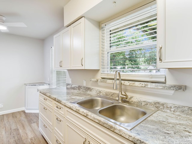 kitchen featuring white cabinets, light hardwood / wood-style floors, and sink