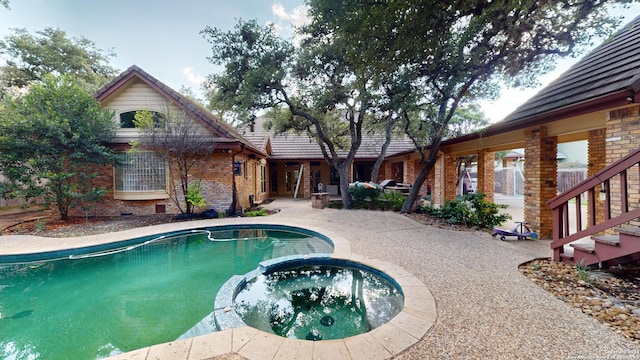 view of swimming pool with an in ground hot tub and a patio area