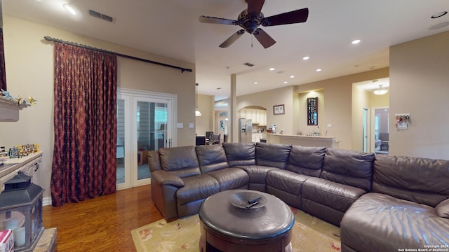 living room featuring ceiling fan and light wood-type flooring