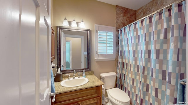 bathroom with vanity, curtained shower, and toilet