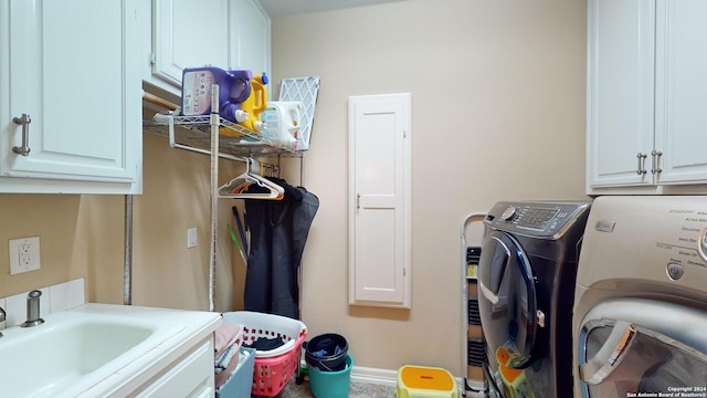 clothes washing area with cabinets, separate washer and dryer, and sink