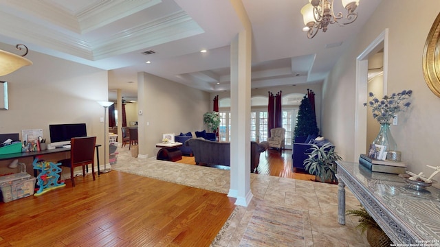 entryway featuring an inviting chandelier, hardwood / wood-style floors, a tray ceiling, and ornamental molding