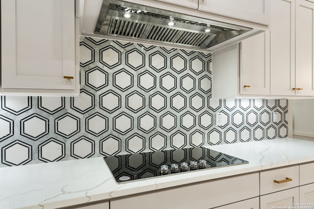 details featuring decorative backsplash, stovetop, and range hood