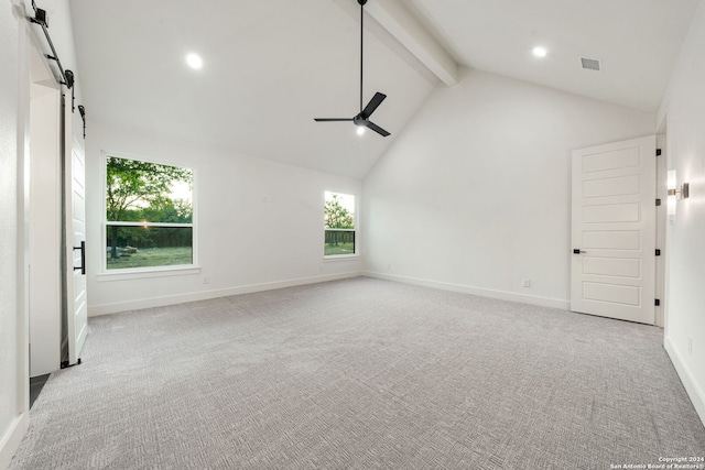 interior space featuring light colored carpet, ceiling fan, beam ceiling, a barn door, and high vaulted ceiling