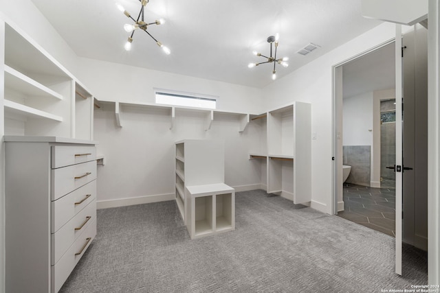 walk in closet featuring a chandelier and carpet