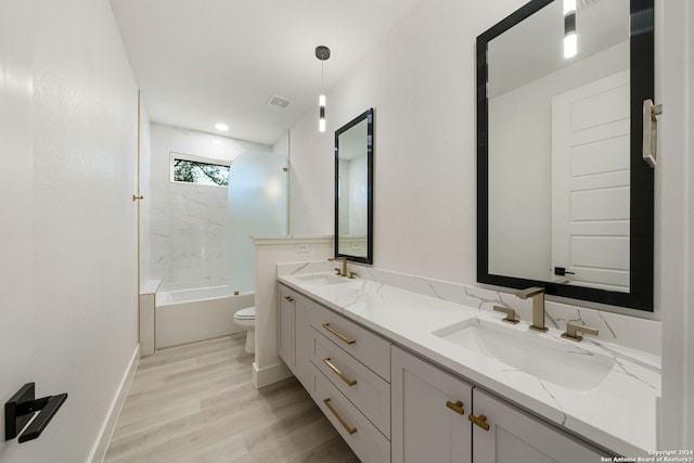 full bathroom with wood-type flooring, vanity, shower / bath combination, and toilet