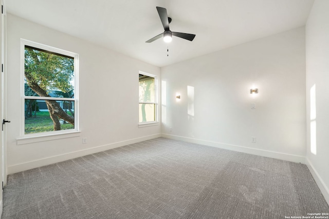 carpeted spare room featuring ceiling fan