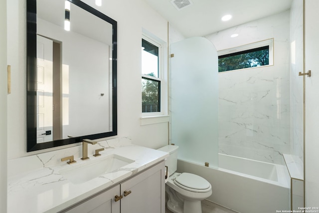 full bathroom featuring toilet, vanity, and tiled shower / bath combo