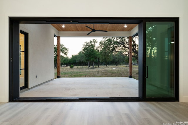 doorway to outside featuring ceiling fan, plenty of natural light, wood ceiling, and light wood-type flooring