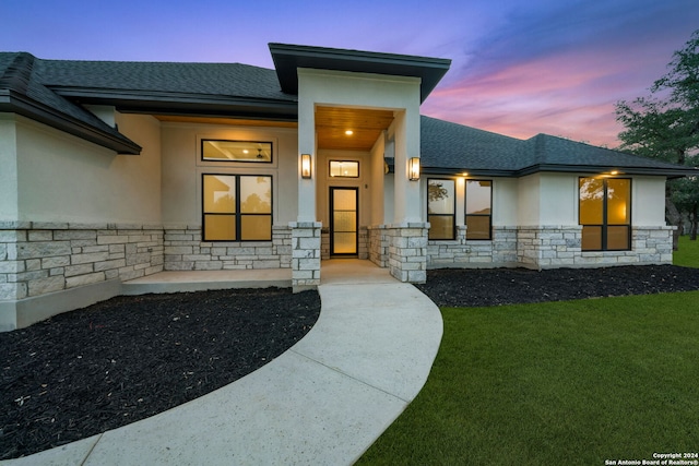 exterior entry at dusk with a yard