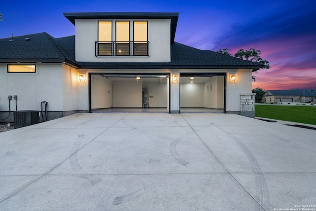 contemporary house with central AC unit and a garage