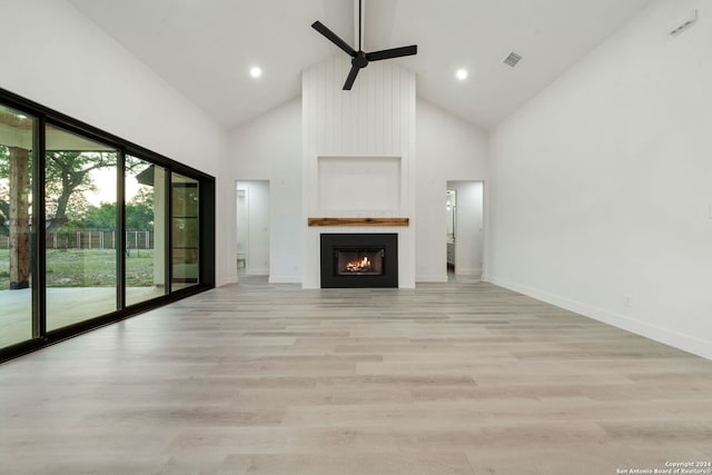 unfurnished living room featuring a fireplace, ceiling fan, light hardwood / wood-style flooring, and high vaulted ceiling