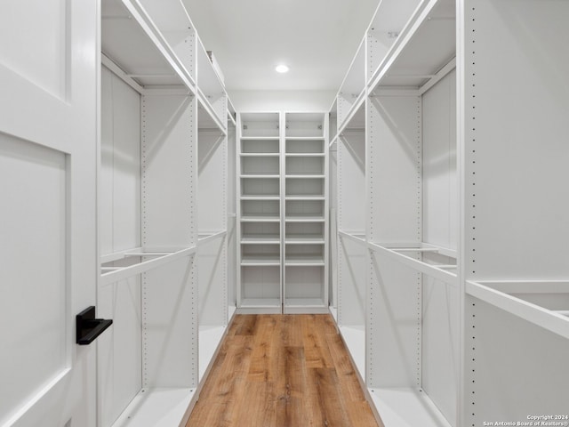 spacious closet with hardwood / wood-style flooring