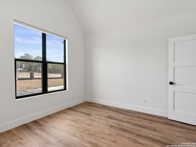 unfurnished room featuring a wealth of natural light, light hardwood / wood-style flooring, and lofted ceiling