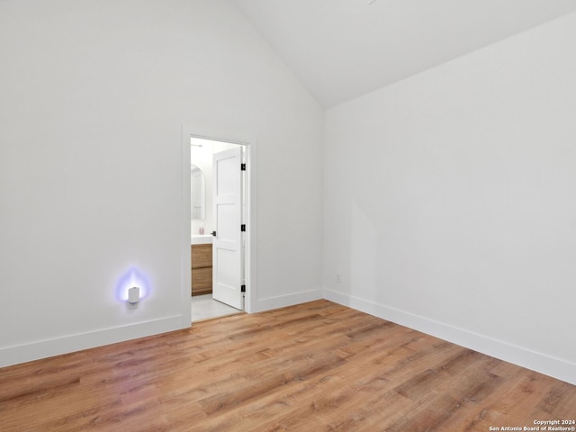 spare room with high vaulted ceiling and light hardwood / wood-style flooring