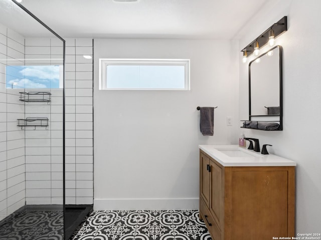 bathroom with tile patterned floors, vanity, and a tile shower