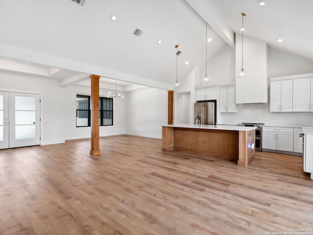 kitchen with light wood-type flooring, stainless steel appliances, a spacious island, decorative light fixtures, and white cabinets