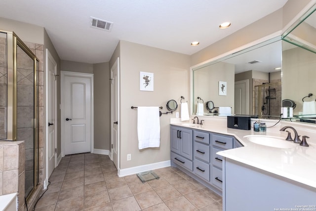 bathroom featuring vanity, a shower with shower door, and tile patterned floors