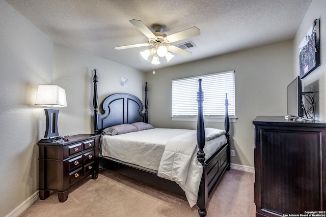 carpeted bedroom with ceiling fan and a textured ceiling