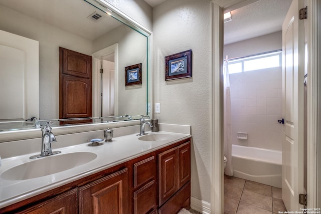 full bathroom featuring tile patterned flooring, vanity, a textured ceiling, shower / washtub combination, and toilet