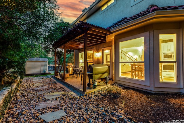 property exterior at dusk with a storage unit