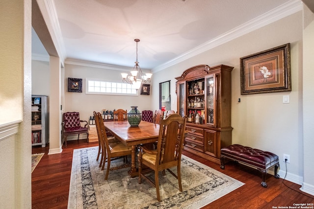 dining area featuring crown molding, dark wood-type flooring, and a chandelier