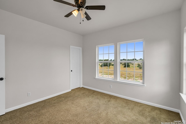 carpeted spare room with ceiling fan