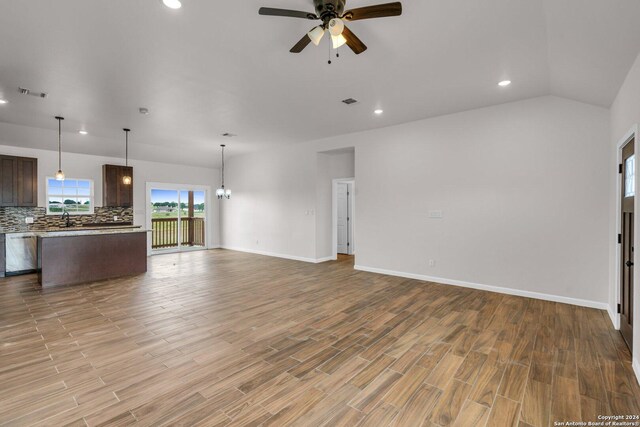 unfurnished bedroom featuring ceiling fan, a closet, ensuite bath, carpet, and a walk in closet